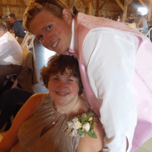 son as groom, leaning over smiling mom in gold dress, best friends