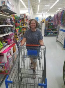 amputee woman, smiling while pushing a shopping cart