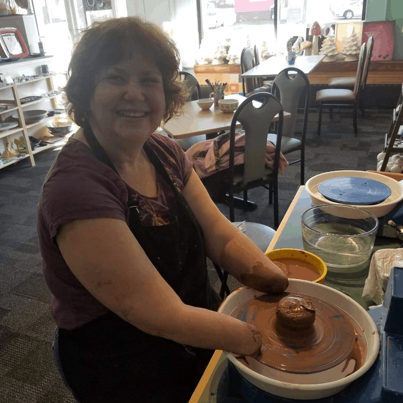 Amputee woman making pottery bowl