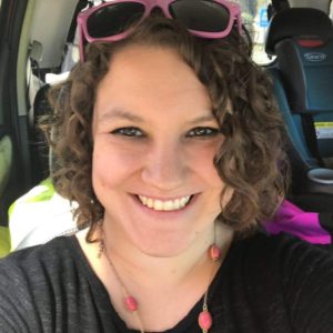 smiling curly haired woman in car