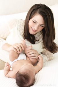 pretty brunette mom playing with baby