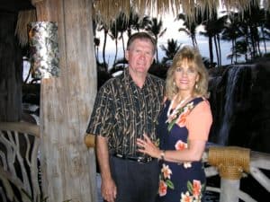 man and woman posing by tree
